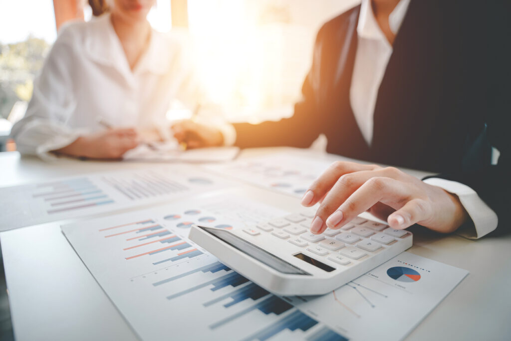 An image illustrating a man and a woman engrossed in financial calculations, surrounded by documents. The central focus is on 'How Finance Services in Malvern East Can Help You Achieve Your Financial Goals.